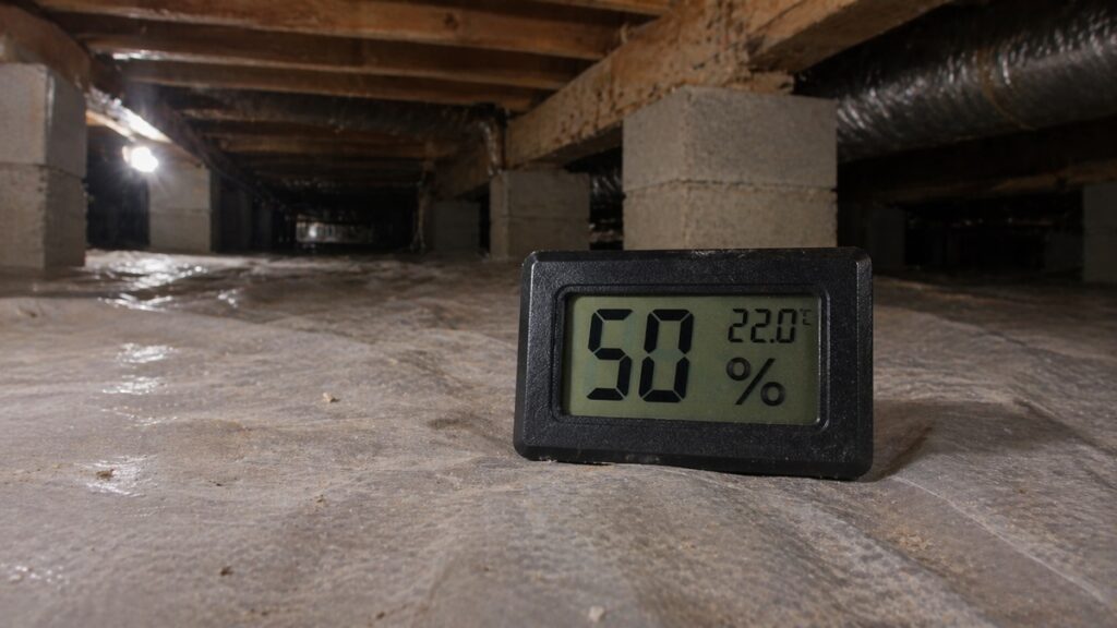 Digital hygrometer showing safe crawl space humidity level