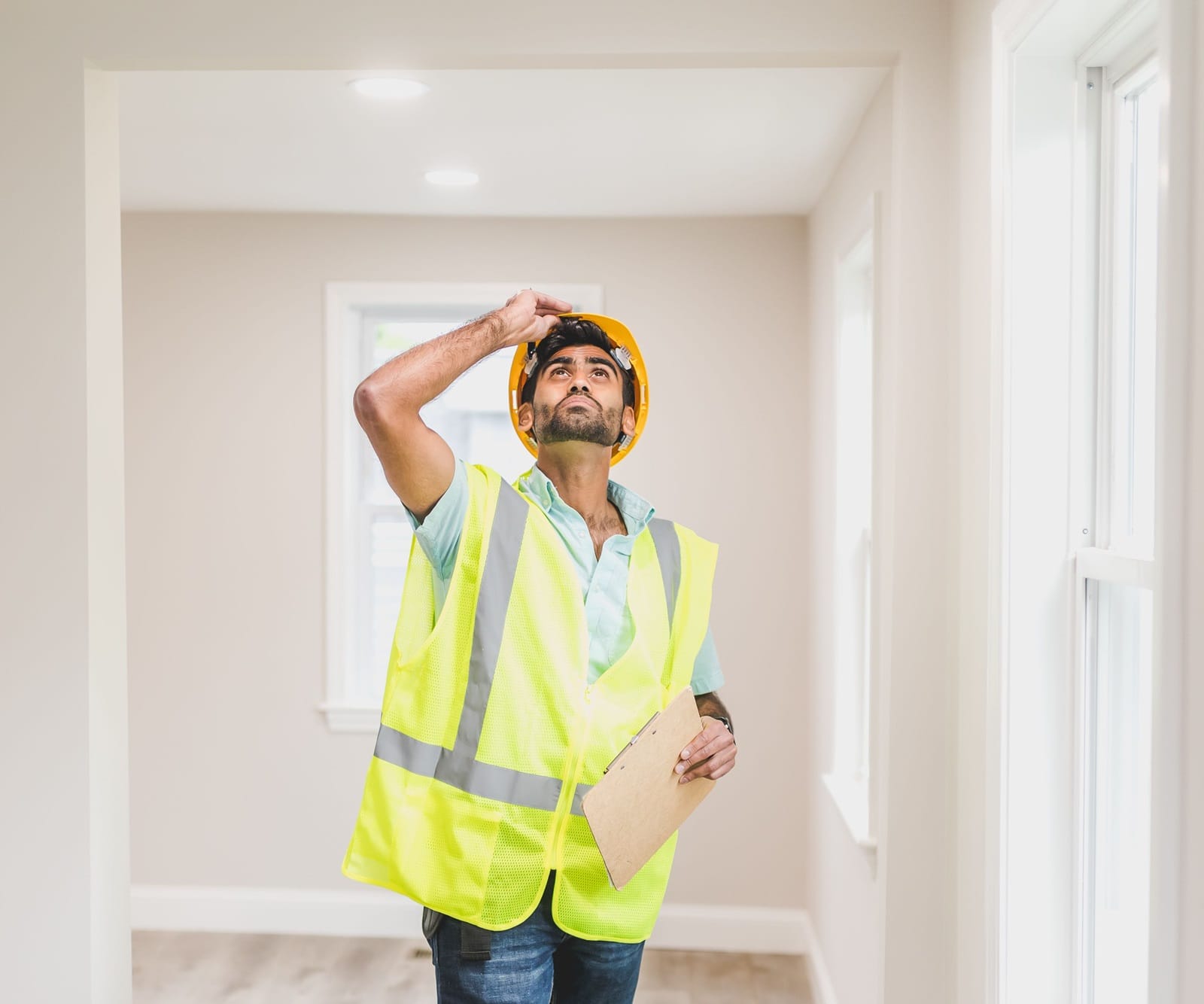 Home inspector checking a ceiling for early signs of a roof leak before mold forms