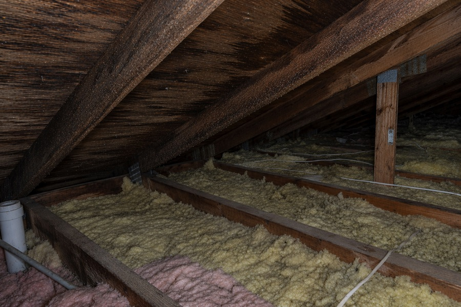 Condensation forming on attic rafters due to poor ventilation