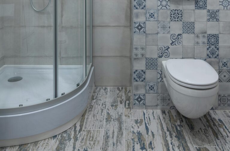 Bathroom with shower, toilet, and tiled floor showing common areas to inspect for hidden leaks