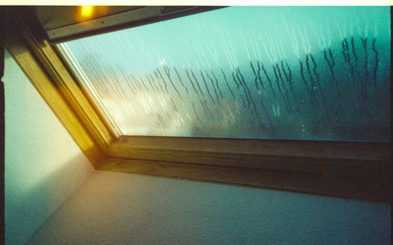 Condensation on a window pane, a common sign of high indoor humidity in a house