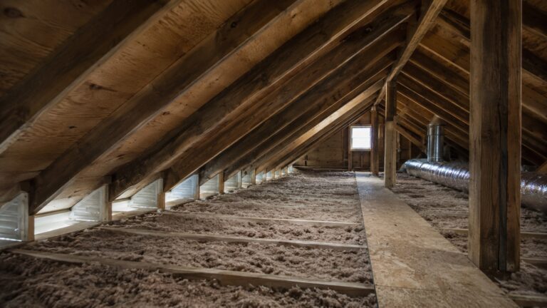 Dry residential attic with insulation between joists, visible eave baffles, open ventilation paths, and properly routed ductwork to prevent moisture build-up.
