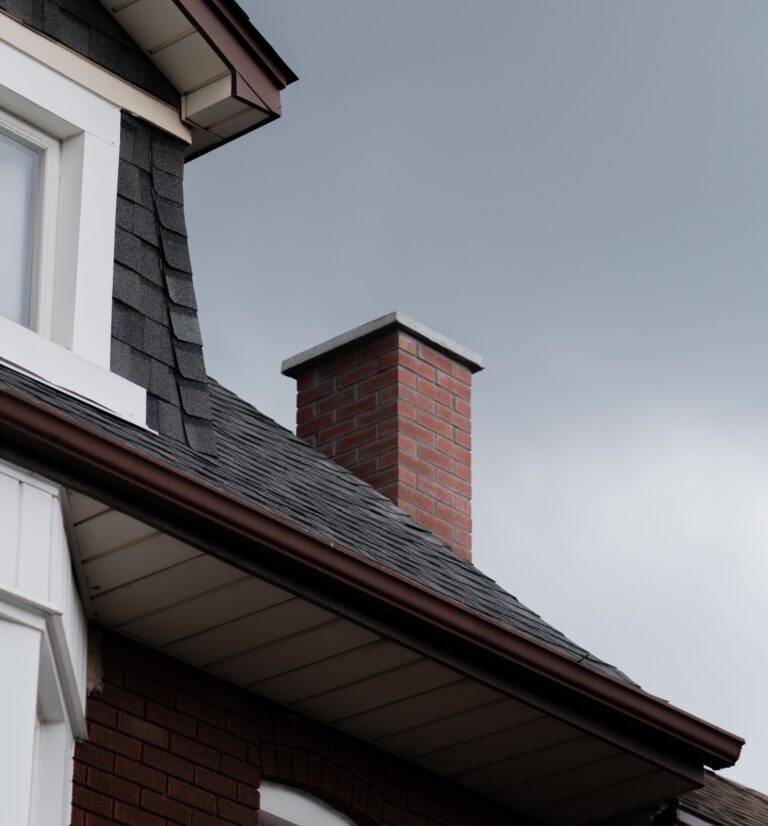 House roof and brick chimney exterior, a common area to inspect for water leaks around chimneys