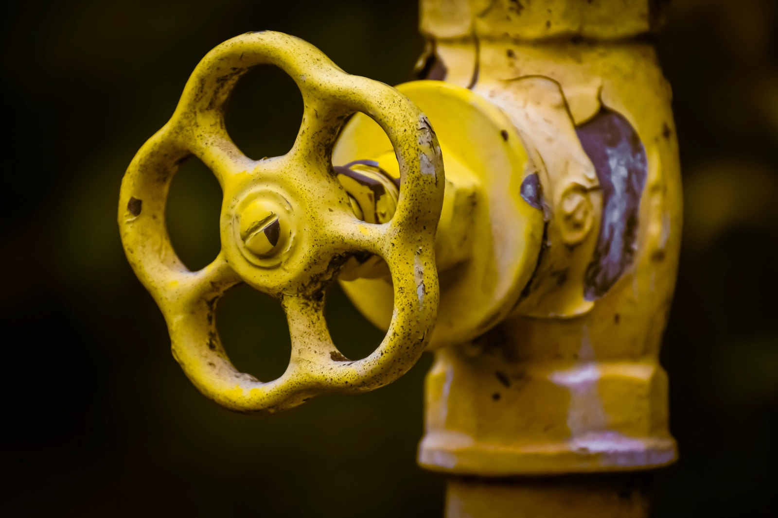 Old yellow shutoff valve on basement plumbing with corrosion and moisture stains showing signs the valve may be failing