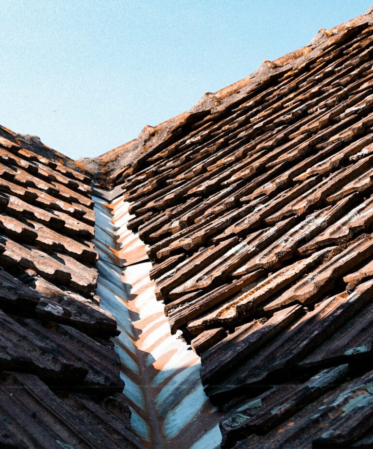 Rusted metal roof valley between tile roof sections showing signs the roof valley may be failing