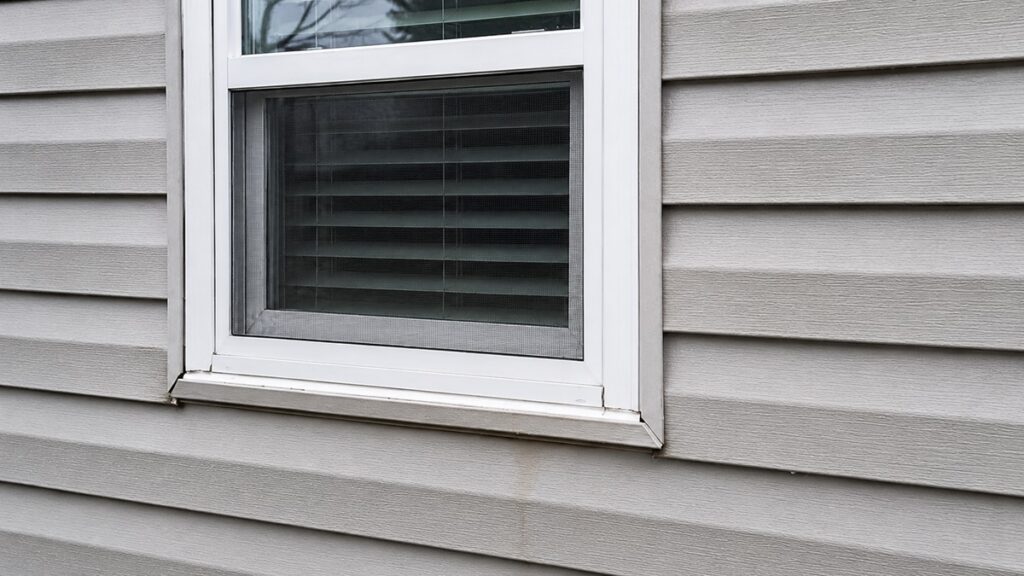Exterior siding and trim showing subtle moisture risk near a joint after rain.